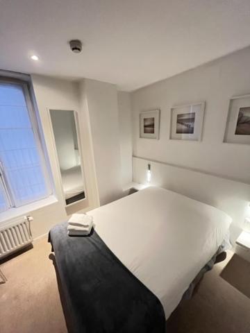 a bedroom with a large white bed and a window at Residence OLit Cathédrale in Strasbourg