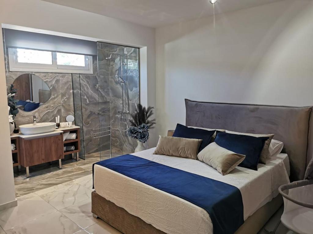 Luxury Apartment Olea Afandou في أفانتو: غرفة نوم بسرير كبير وحمام