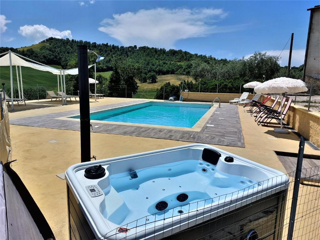 una vasca idromassaggio seduta su un patio accanto alla piscina di Agriturismo La Terrazza a Valfabbrica