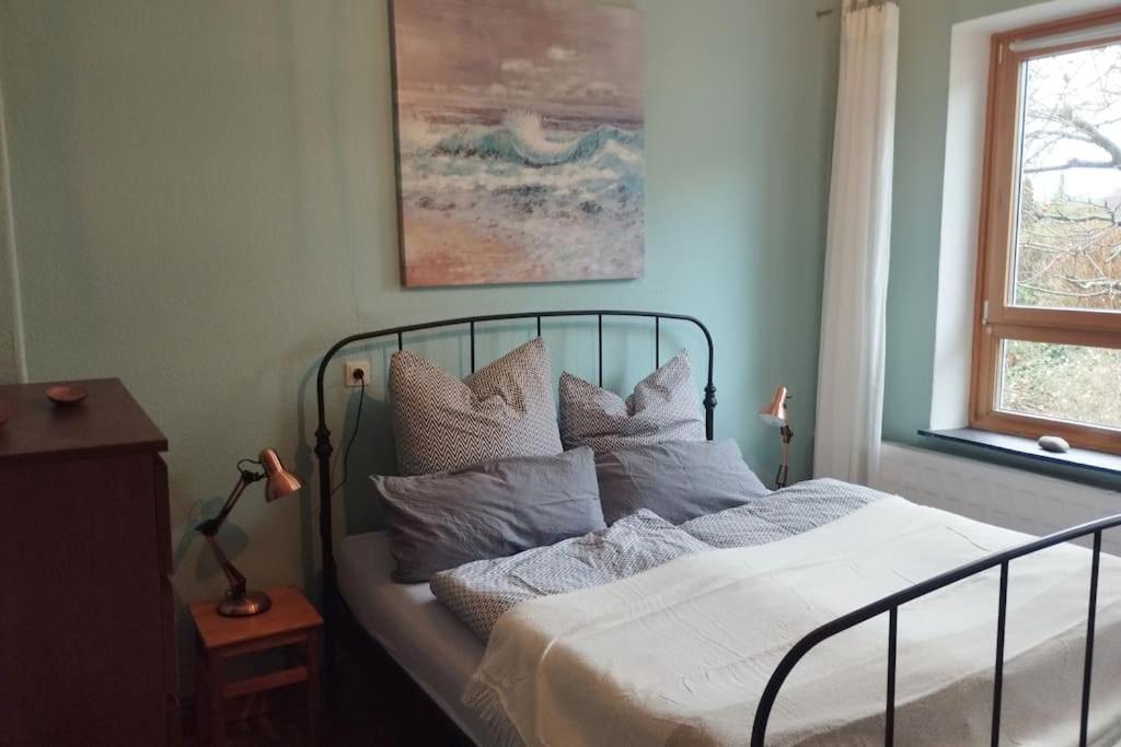 una camera da letto con letto, lenzuola e cuscini bianchi di Ferienwohnung Birklund a Probsteierhagen