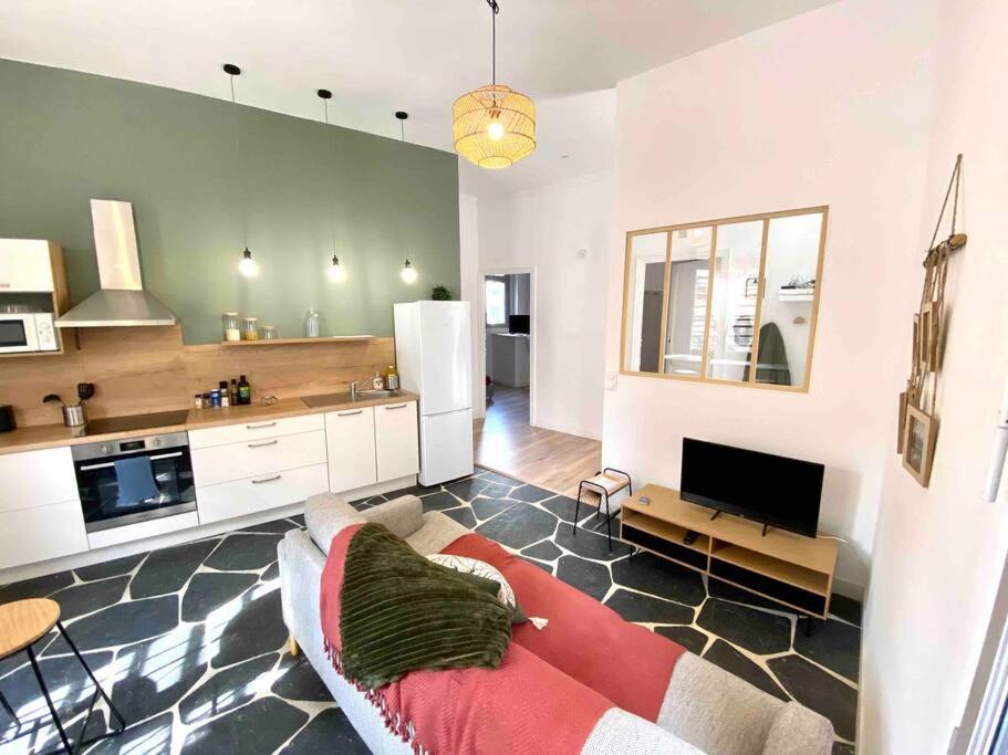 un salon avec un canapé et une cuisine dans l'établissement Béziers - Appartement 3 chambres Parking privee -WIFI -Clim, à Béziers