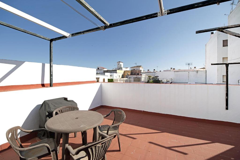 a patio with a table and chairs on a roof at Dúplex Chanca in El Puerto de Santa María