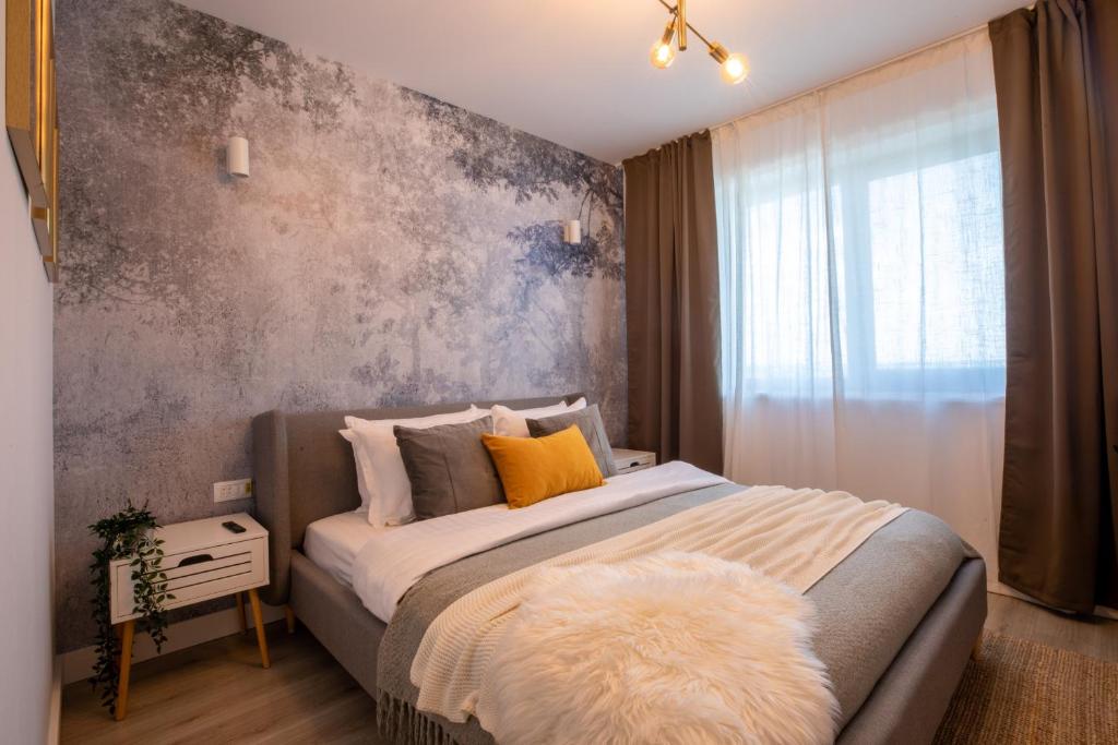 1 dormitorio con 1 cama grande y pared gris en Stunning 1BR Retreat in North District en Bucarest