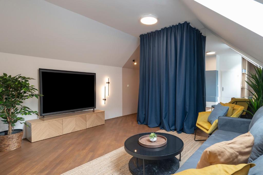 a living room with a large television and a couch at Strict city apartments in Ljubljana