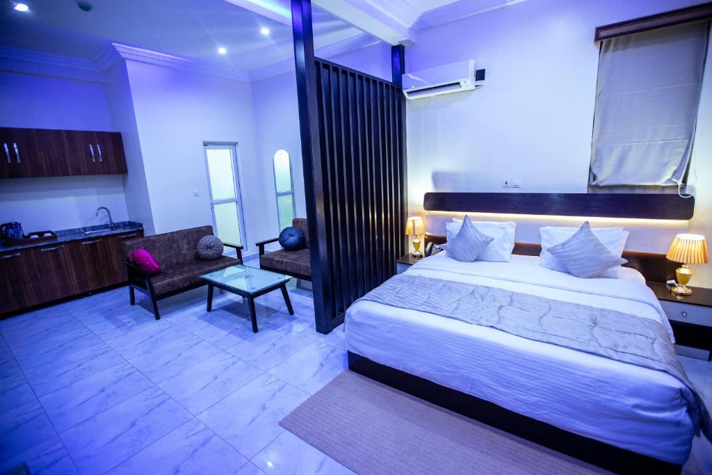 a hotel room with a bed and a kitchen at Apartment 79 Hotel in Ikeja
