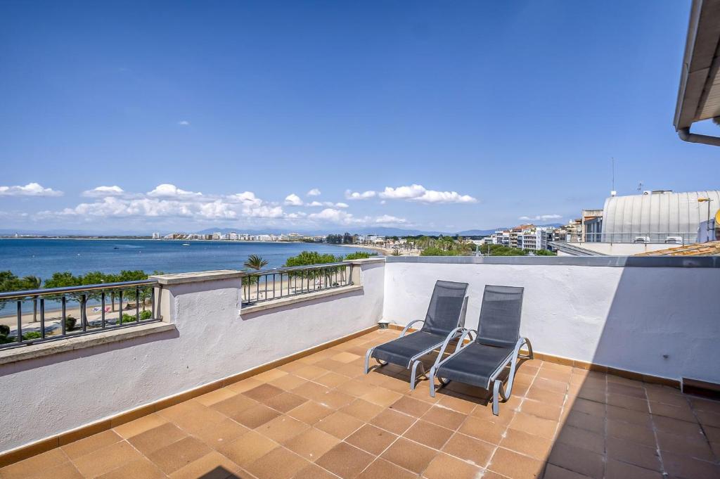 two chairs on a balcony with a view of the ocean at Gregal Atico Roses - Immo Barneda in Roses