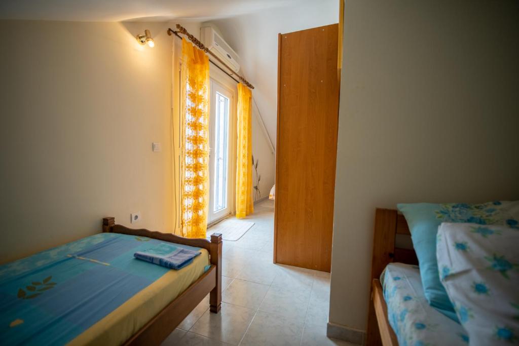 a bedroom with two beds and a window at ARI Apartments in Krašići