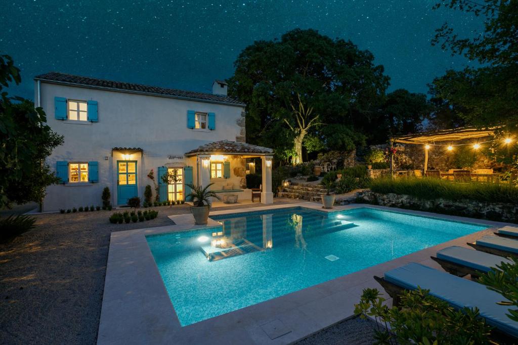 una casa con piscina por la noche en Heritage Villa Laurel en Malinska