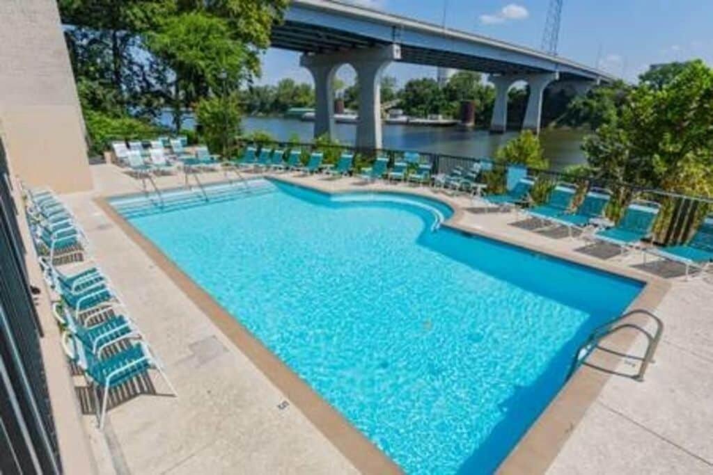 uma grande piscina com cadeiras e uma ponte em Captain's Quarters Riverfront #3 em Nashville