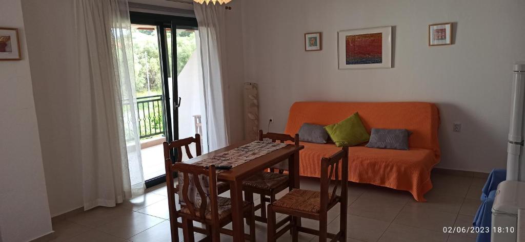 a living room with a table and a couch at Orange Tree Garden in Pefkochori
