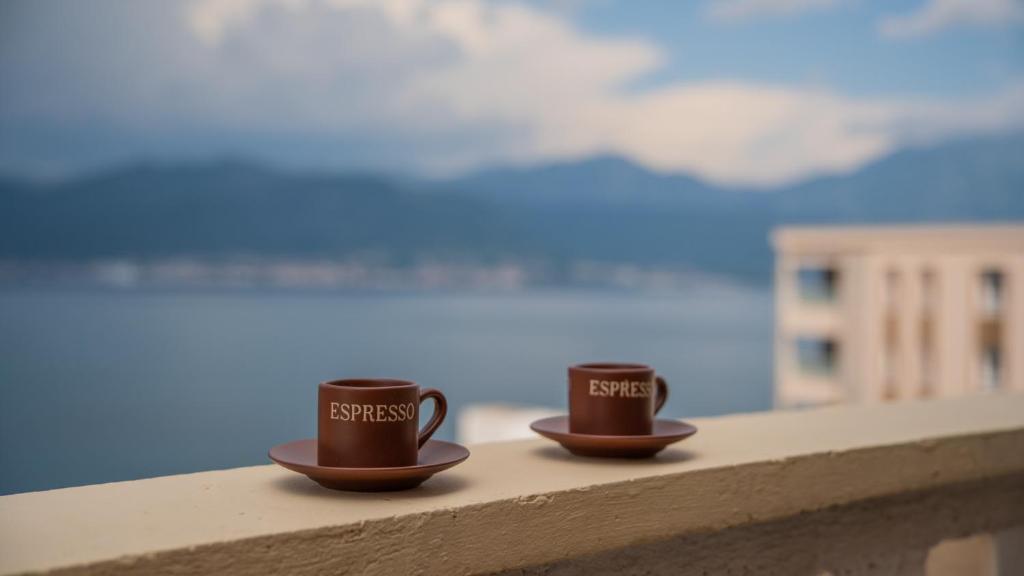 two coffee cups sitting on top of a ledge at ARI Apartments in Krasici