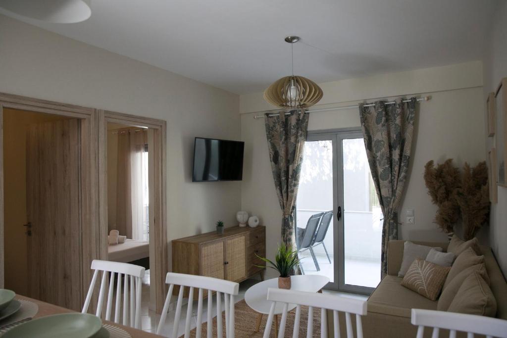 Una sala de estar con un sofá y un televisor. en Azur Deluxe apt., en Pefkohori