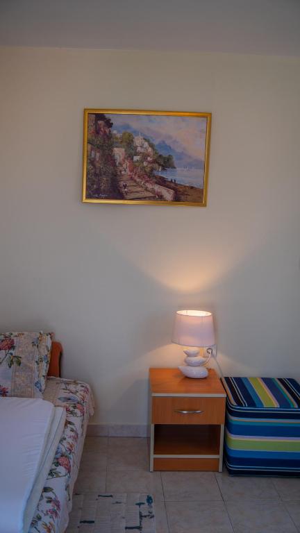 a bedroom with a bed and a table with a lamp at ARI Apartments in Krašići