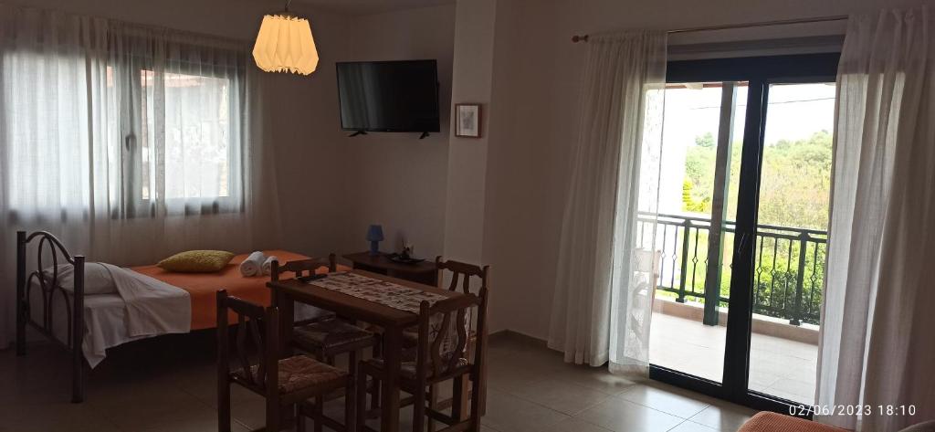 a dining room with a table and a balcony at Orange Tree Garden in Pefkochori