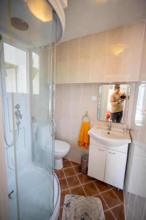 a man taking a picture of a bathroom with a mirror at ARI Apartments in Krašići