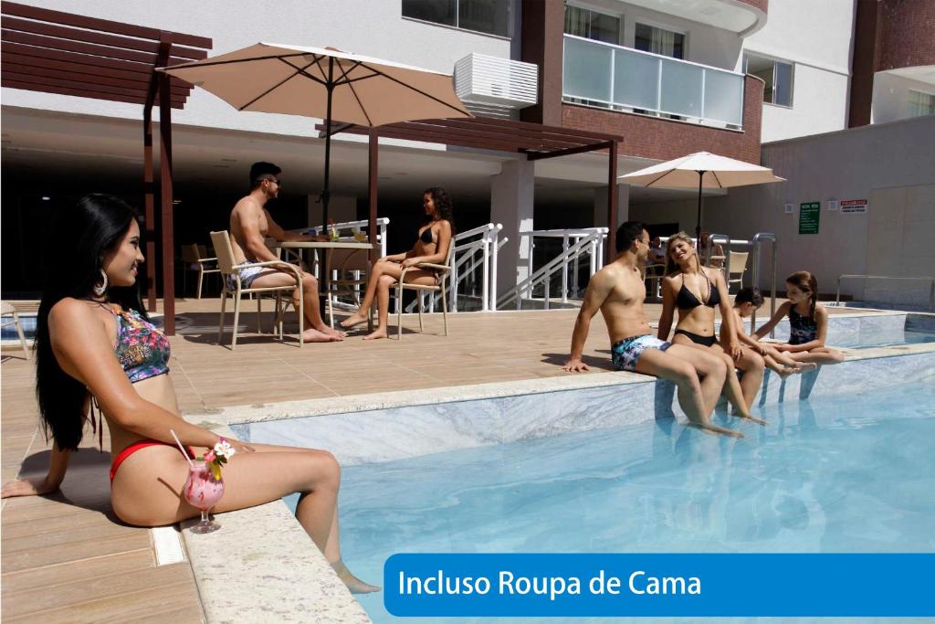 un grupo de personas sentadas en una piscina en Everest Flat Service, en Caldas Novas