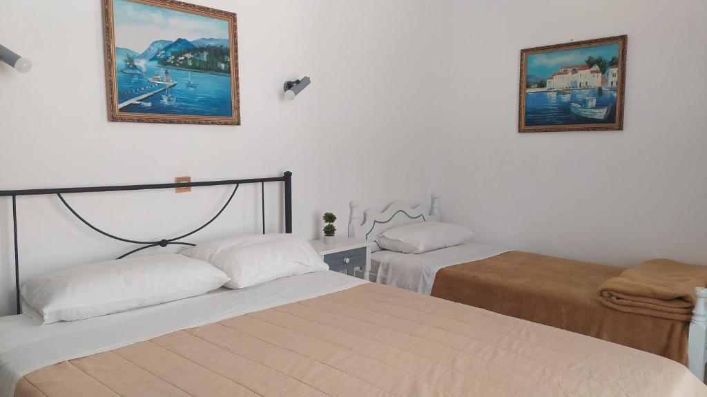 - une chambre avec 2 lits et 2 photos sur le mur dans l'établissement Nitsas studio's, à Kremasti