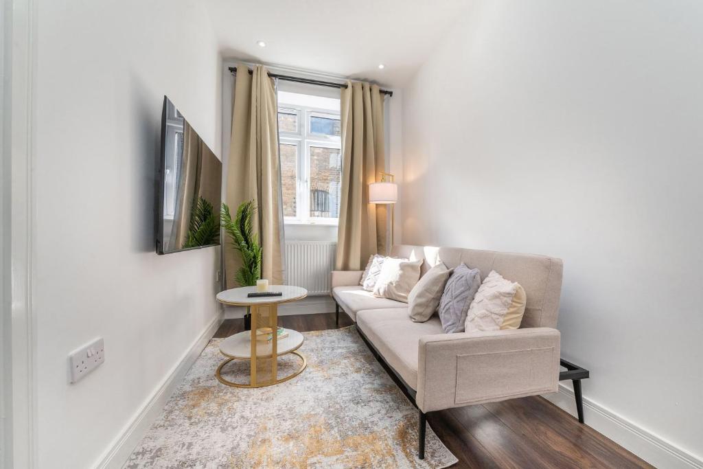 a living room with a couch and a table at Luxury Apartment near Central London in London