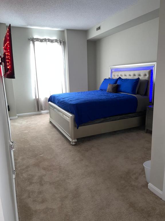 um quarto com uma cama com lençóis azuis e uma janela em Luxury penthouse apartment em Baltimore