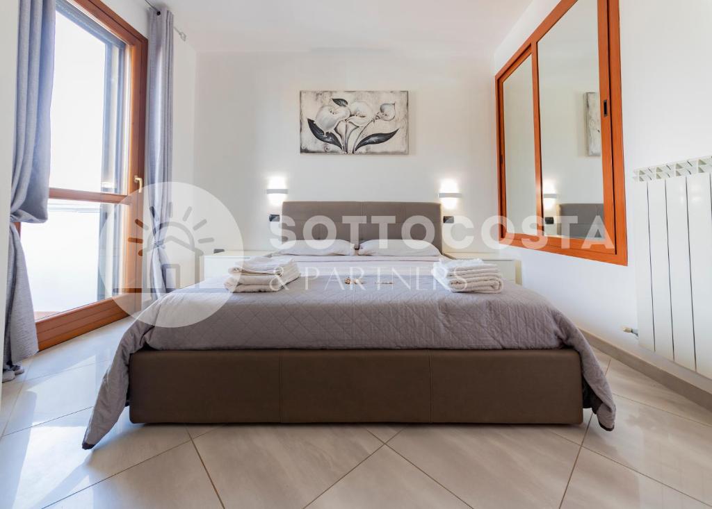 ein Schlafzimmer mit einem Bett und einem großen Fenster in der Unterkunft Villino Montale in Porto Cesareo