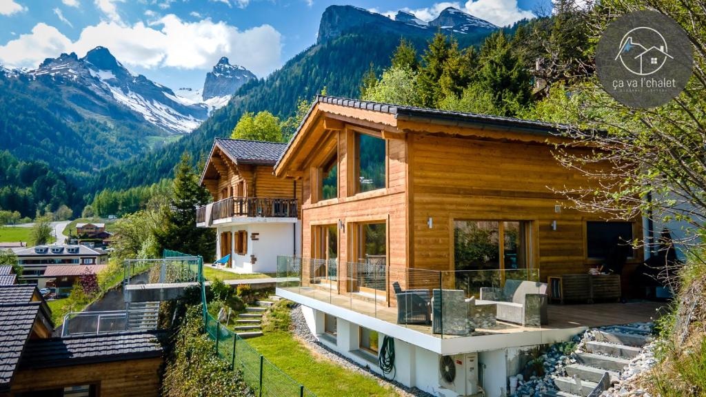 ein Holzhaus mit Bergen im Hintergrund in der Unterkunft Chalet de charme l'O in Ovronnaz