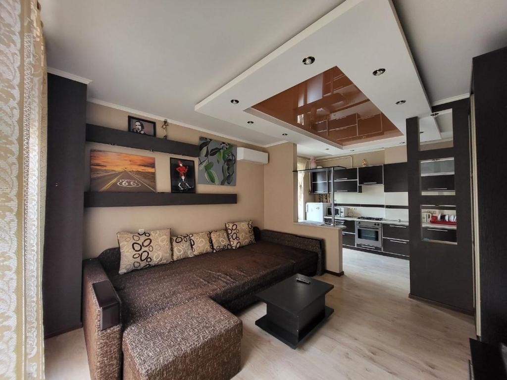 ein Wohnzimmer mit Couch und Küche in der Unterkunft 1 кімнатна квартира-студія в новобудові in Czernowitz