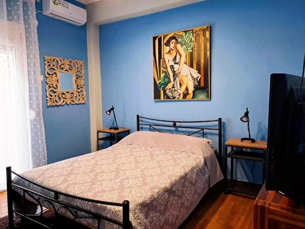 雅典的住宿－ART APART，卧室配有一张床,墙上挂有绘画作品