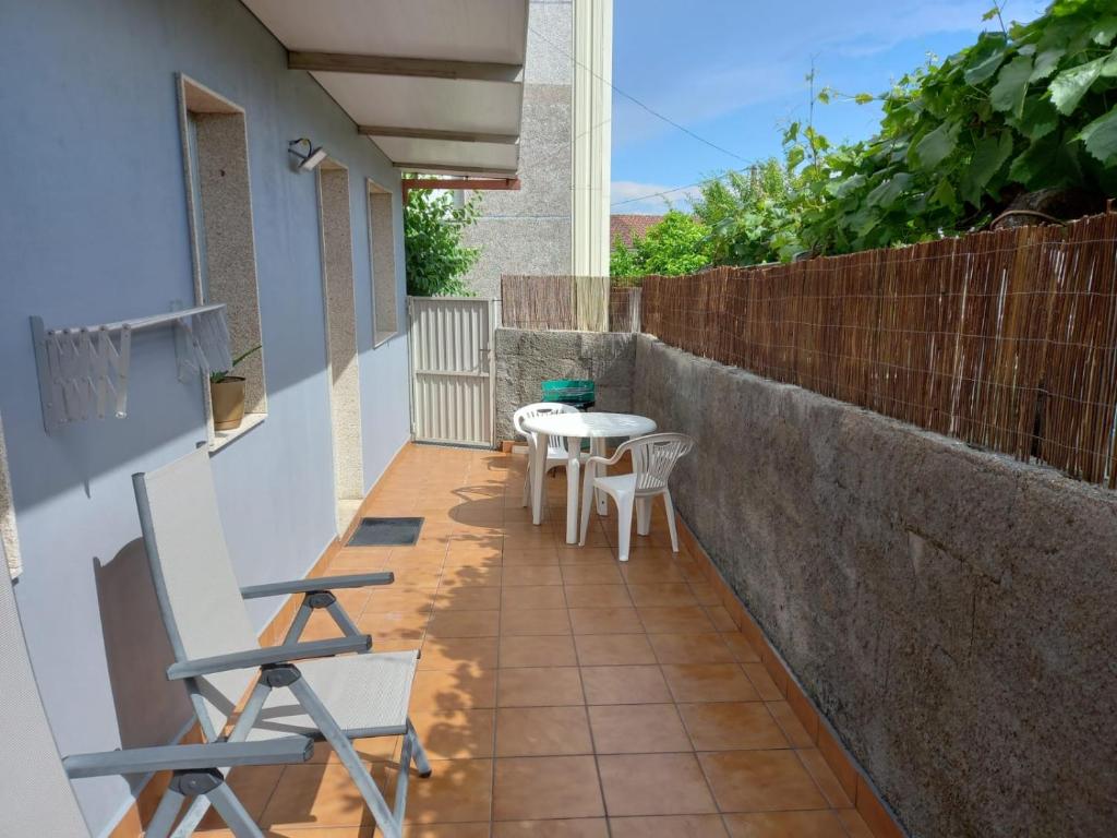 a small balcony with a table and chairs on it at Casa Maside Orense in Maside