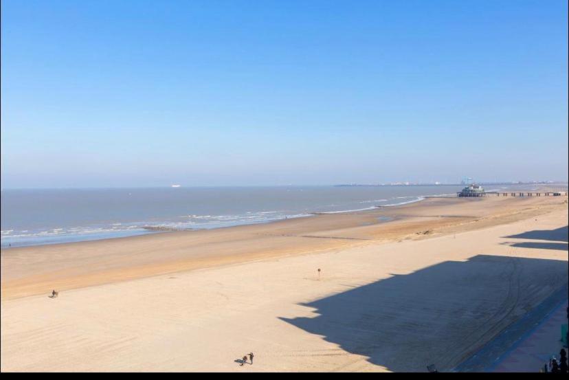 a view of a beach with people walking on the sand at Golfsuite 13 in Blankenberge