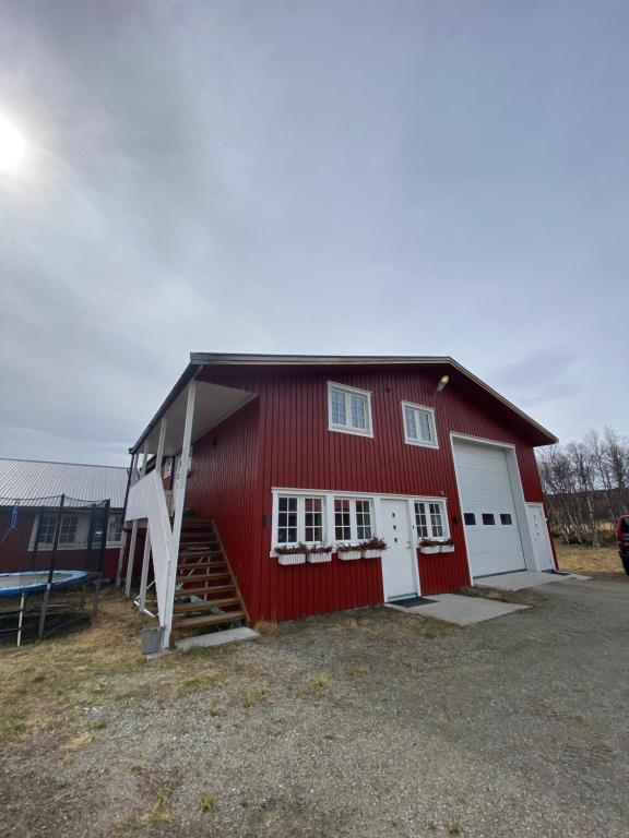 a red barn with white doors and a staircase at Leilighet Sølendet, i Brekken ved Røros in Røros