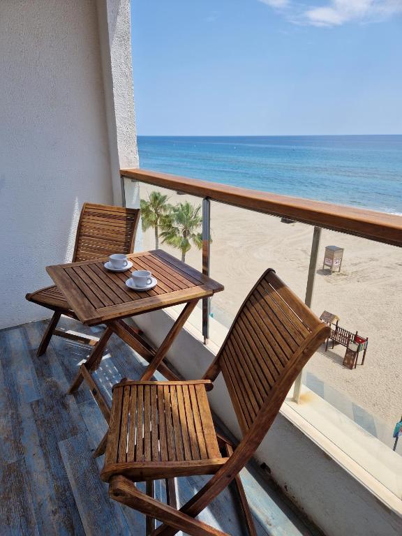 a table and chairs on a balcony with the beach at Apartamentos Wundermar in Torredembarra