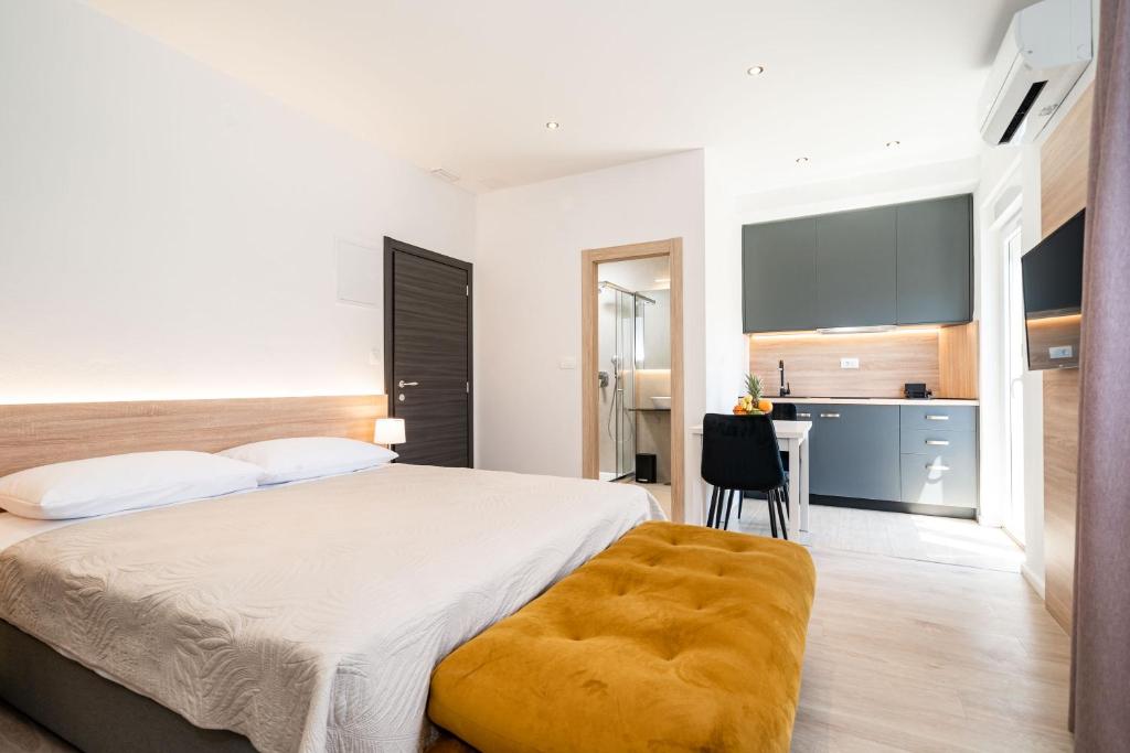 um quarto com uma cama grande e uma secretária em Bacan Serviced Apartments em Cavtat
