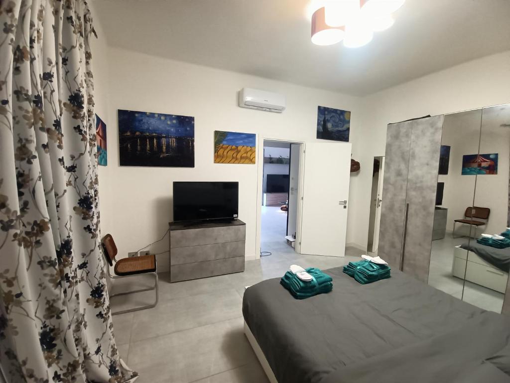 una camera da letto con un letto e una TV a schermo piatto di City View! Panoramic Apartment overlooking La Spezia a La Spezia