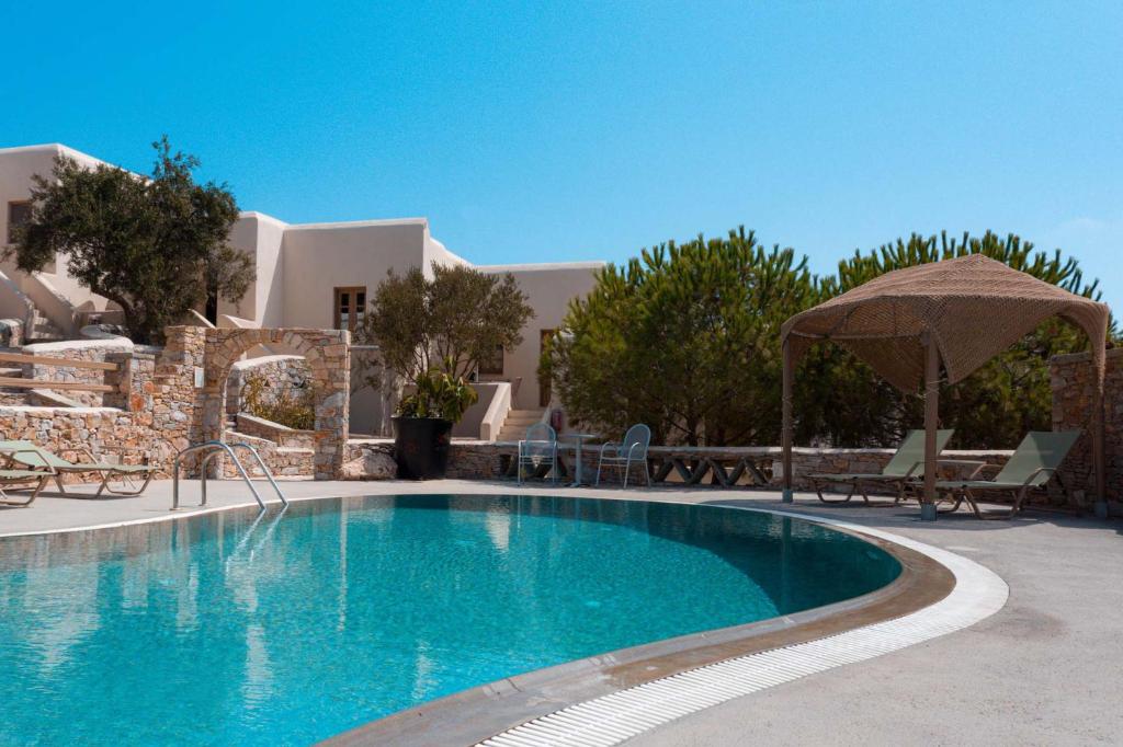 a swimming pool in front of a villa at XARAKI Traditional Houses in Chora Folegandros