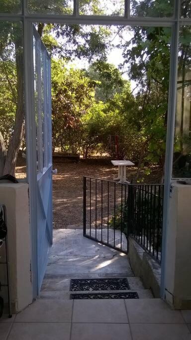 - une porte ouverte menant à une terrasse couverte avec un portail dans l'établissement Maison de ville lumineuse avec jardin, à Gardanne