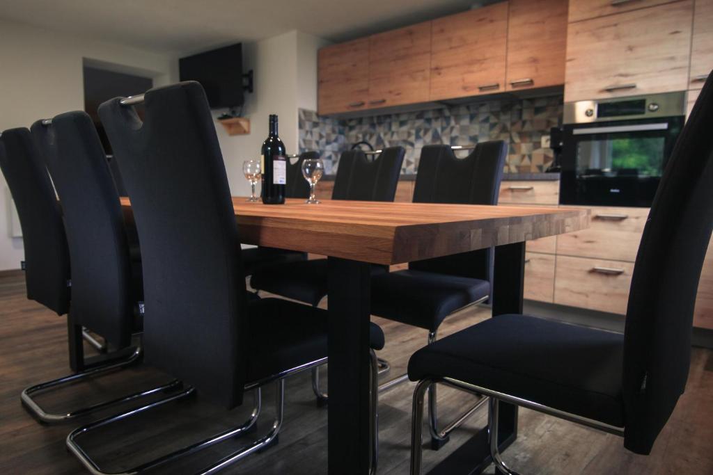 eine Küche mit einem Holztisch und schwarzen Stühlen in der Unterkunft Apartma Gorski razgled in Srednja Vas v Bohinju
