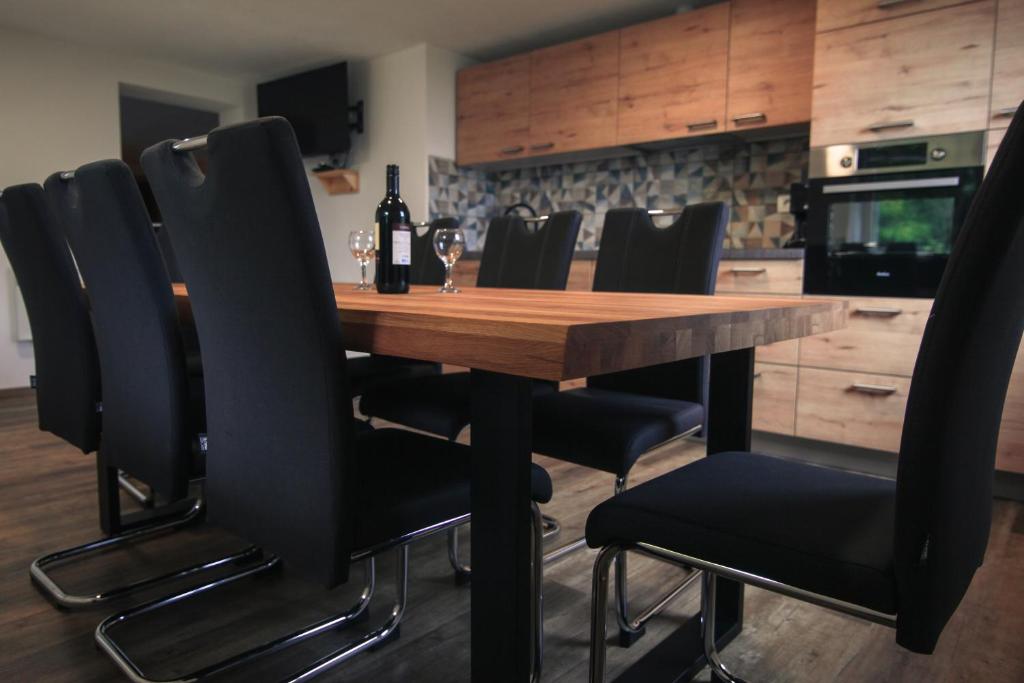 a kitchen with a wooden table and black chairs at Apartma Gorski razgled in Srednja Vas v Bohinju