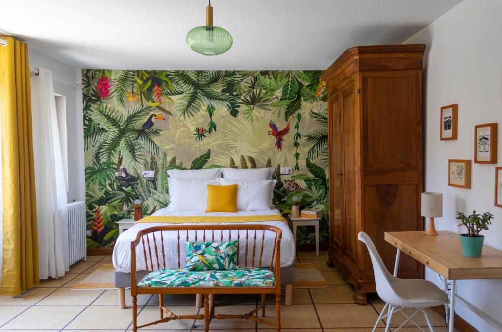 a bedroom with a bed with a tropical wallpaper at Maison et table d'hôtes Le Camélia Blanc in Saint-Ciers-sur-Gironde