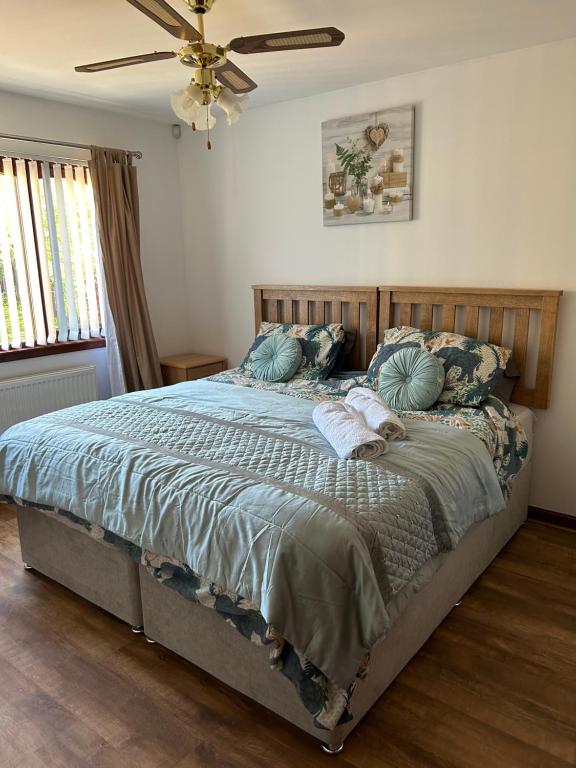 a bedroom with a large bed with blue sheets and pillows at Willow Lodge , Corskie Drive Macduff-Banff in Macduff