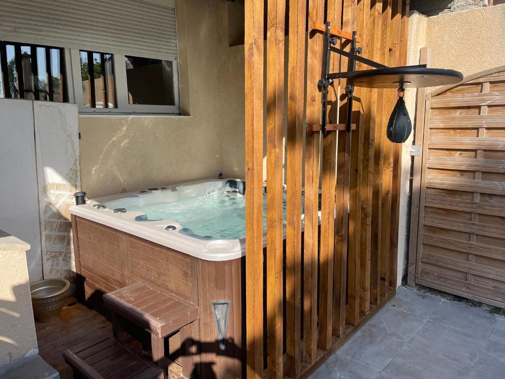- un bain à remous dans une pièce dotée d'une clôture en bois dans l'établissement Luxury, à Amiens