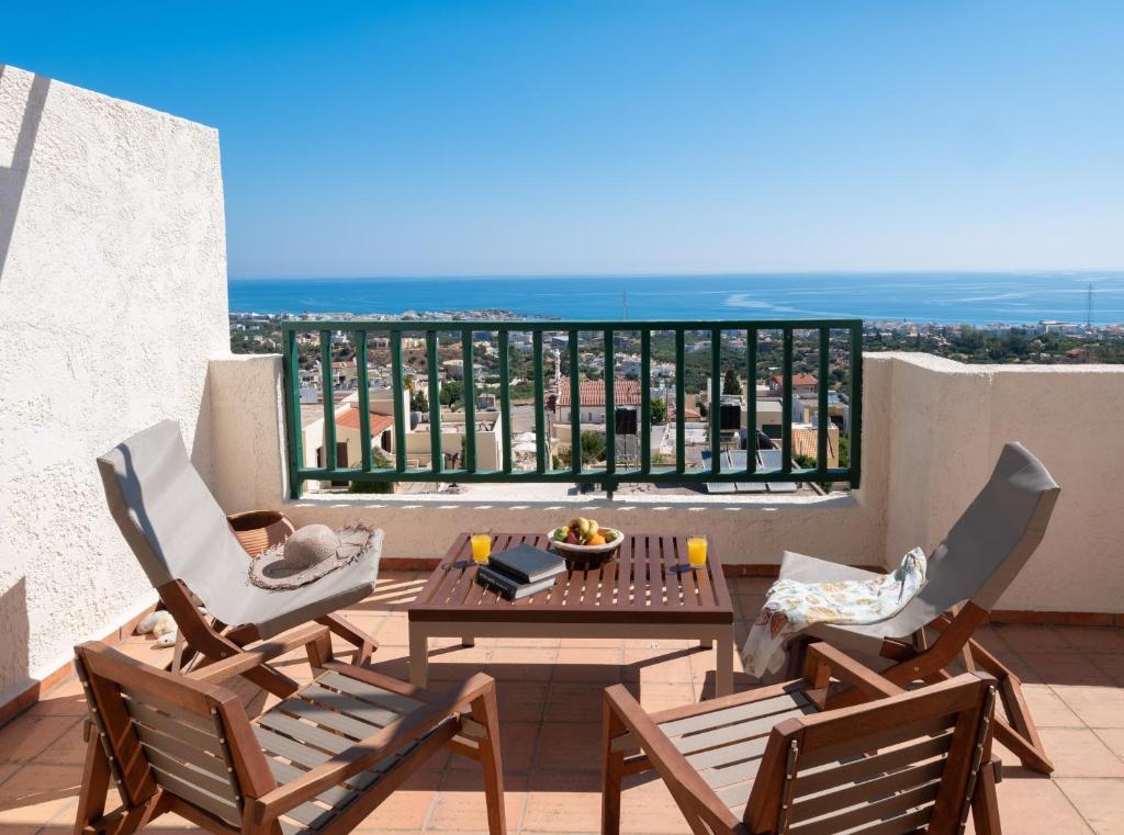 a balcony with chairs and a table with a view at Kalimera Village in Hersonissos