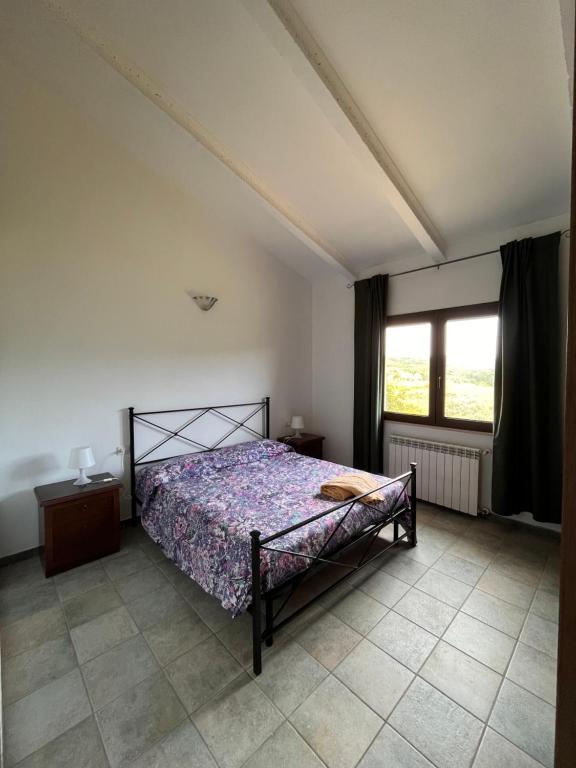 sypialnia z łóżkiem i dużym oknem w obiekcie Agriturismo Pian di Farinello w mieście Casa Pallini