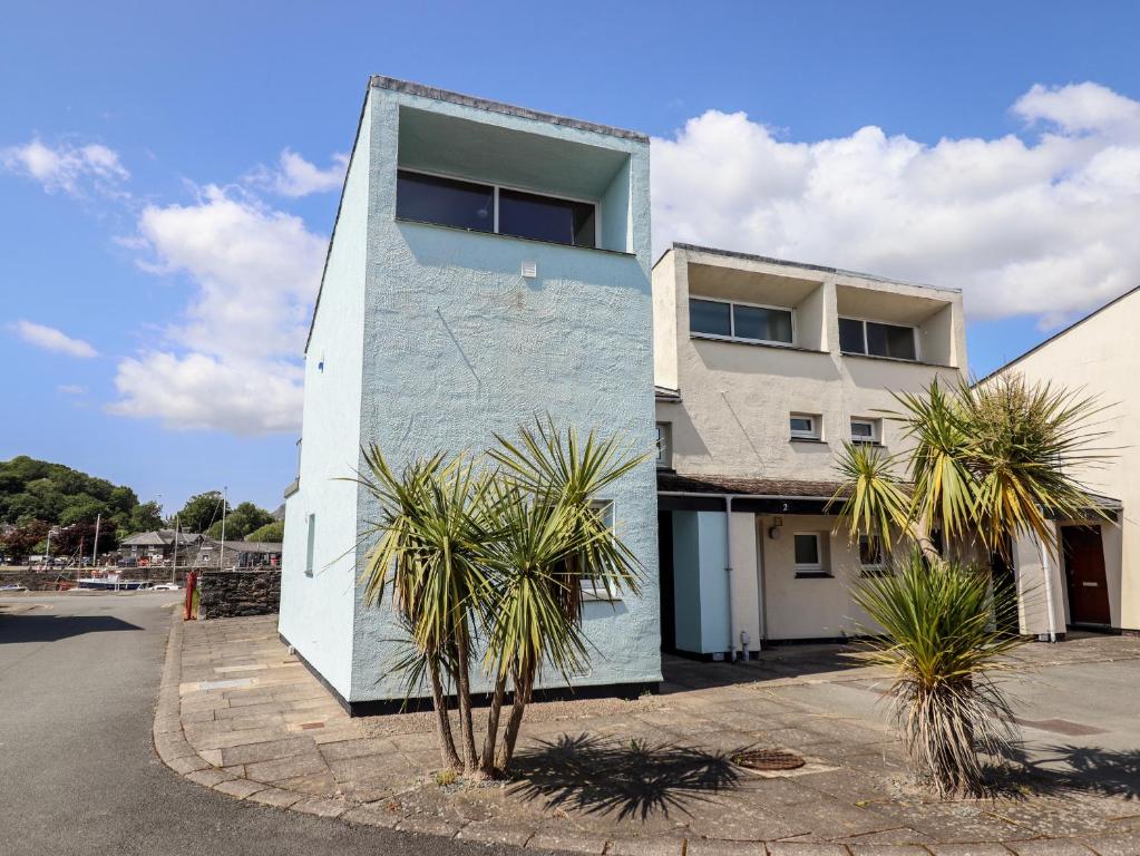 a building with palm trees in front of it at 1 South Snowdon Wharf in Porthmadog