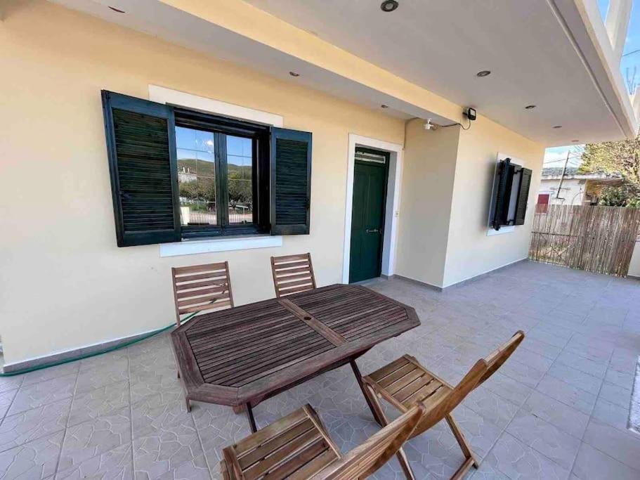 eine Terrasse mit einem Holztisch und 2 Stühlen in der Unterkunft Κυδωνιά Μάνη in Vathy
