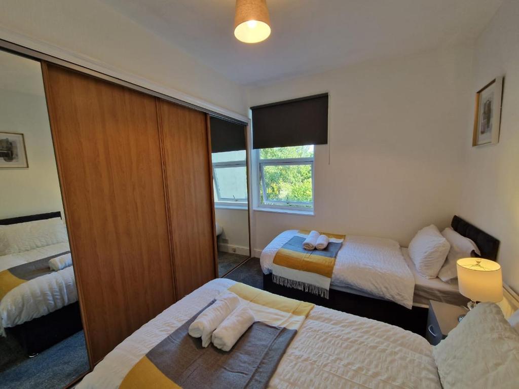 a hotel room with two beds and a window at Swanley Guest House in Kent