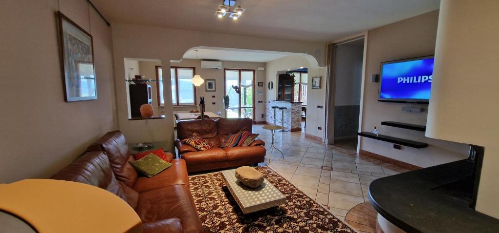sala de estar con muebles de cuero y TV de pantalla plana en Villa Monica Terni - uso esclusivo en Terni