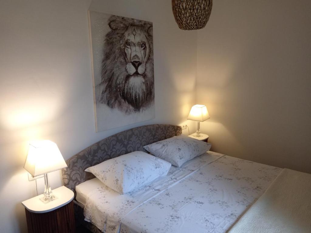 sypialnia z łóżkiem ze zdjęciem lwa w obiekcie Seaview Holiday Apartments, Ventura Nin w Nin