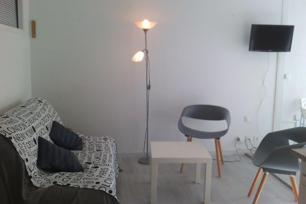 un salon avec un canapé et une chaise dans l'établissement APPARTEMENT P2 + CABINE LE GRAU DU ROI, au Grau-du-Roi