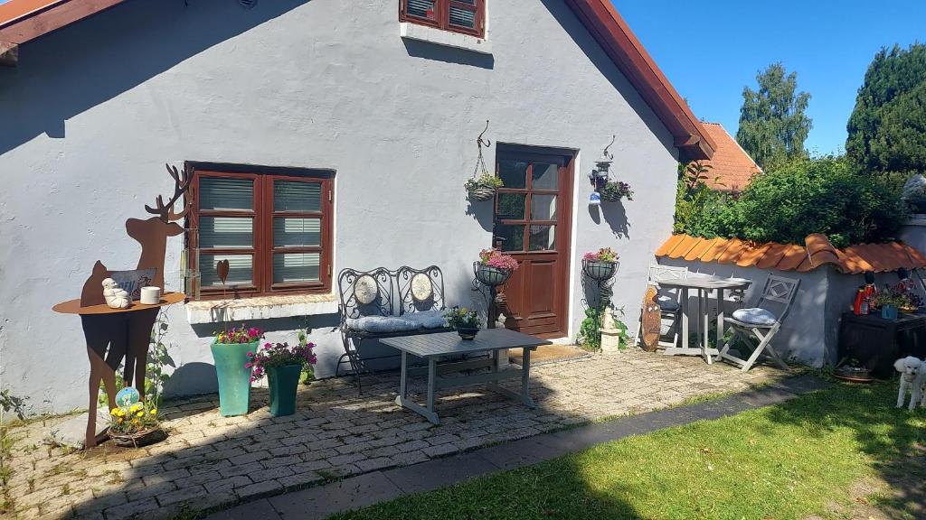 ein weißes Haus mit einer Bank davor in der Unterkunft KRAGKAER Deer-Lodge B&B A unique holiday home in Sæby