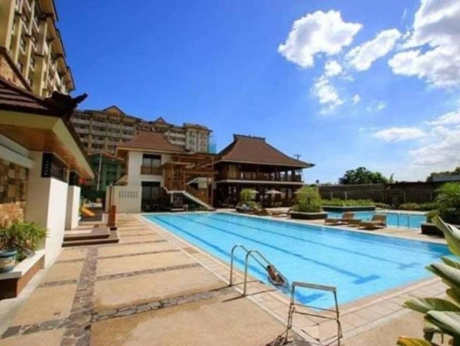 ein großer Pool in der Mitte eines Gebäudes in der Unterkunft Cozy Condo in Pasig City- Bali Oasis 2 in Manila